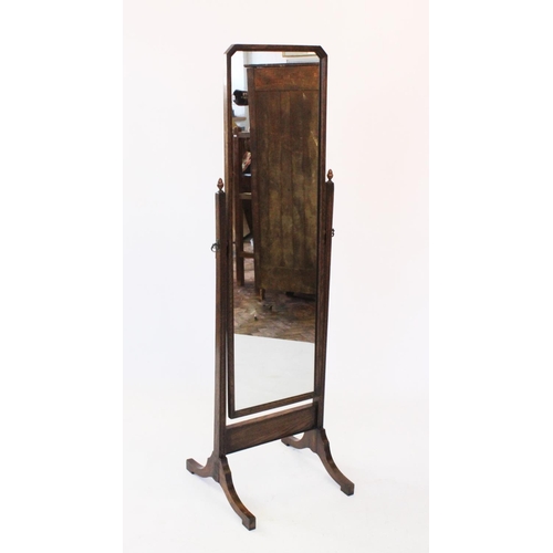 807 - An early 20th century oak cheval mirror, the rectangular mirror with canted top corners, raised upon... 