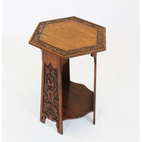 808 - An early 20th century Arts and Crafts oak occasional table, the hexagonal top with a leaf carved fri... 