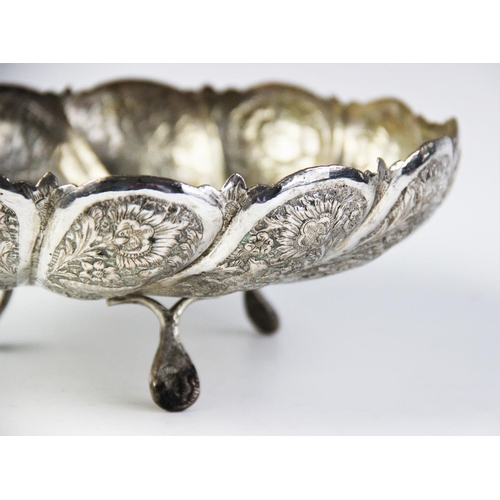 82 - A Persian white metal tripod bowl, of circular scalloped form on three feet, with engraved and embos... 