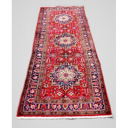 668 - A large red ground Persian Tabriz runner, with unique starburst medallion design, 335cm x 127cm