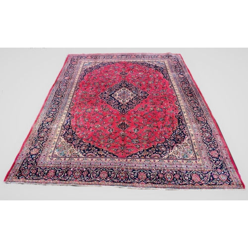 672 - A large Persian mashad carpet, with traditional floral medallion design against a puce ground, 375cm... 