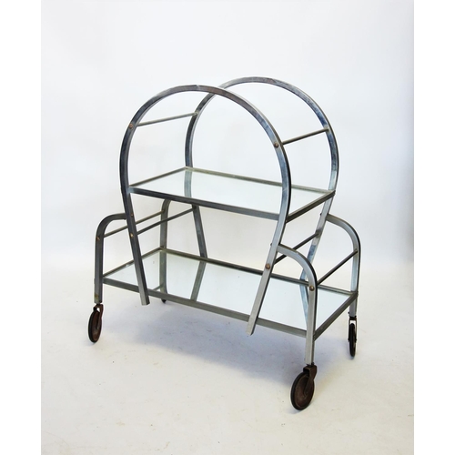 814 - An Art Deco chromed and mirrored drinks trolley, the curved chromed box section enclosing two mirror... 