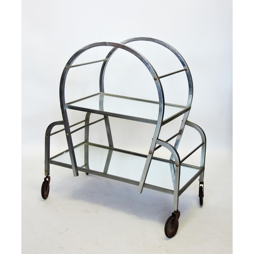 814 - An Art Deco chromed and mirrored drinks trolley, the curved chromed box section enclosing two mirror... 