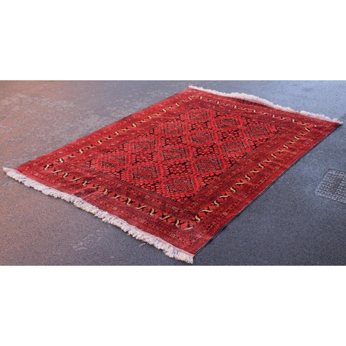 676 - A Bokhara style carpet, the red ground with twelve lozenge shaped medallions punctuated by floral lo... 