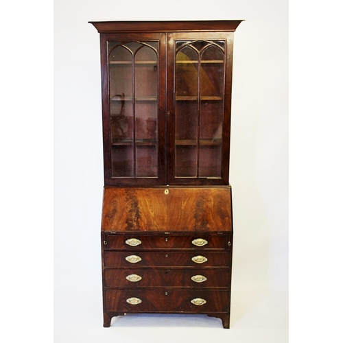 767 - An early 19th century mahogany bureau bookcase, with a moulded tapering cornice above a pair of glaz... 