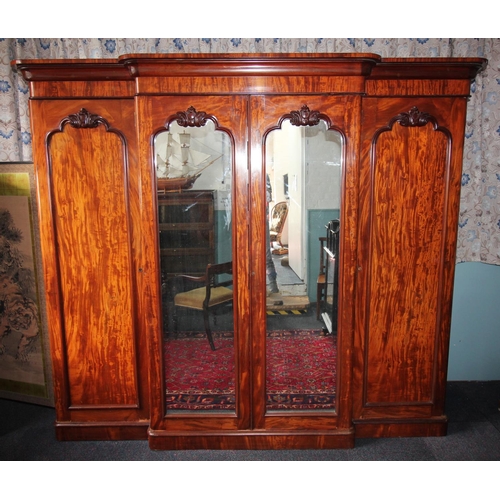 784 - A Victorian mahogany breakfront four door wardrobe, with a cavetto cornice above a pair of central m... 