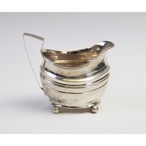 109 - A George III silver cream jug, of oval form on four ball feet with engraved decoration to border and... 