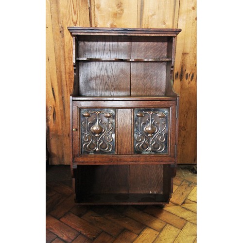 798 - An early 20th century oak Art Nouveau wall hanging cabinet, with a recessed shelf above a cupboard d... 