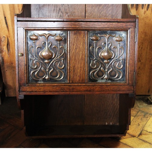 798 - An early 20th century oak Art Nouveau wall hanging cabinet, with a recessed shelf above a cupboard d... 