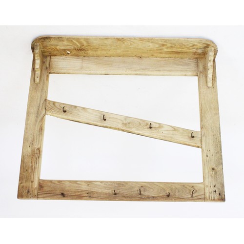 756 - A rustic pine hanging wall rack, with a rectangular shelf above a pair of uprights united by an angl... 