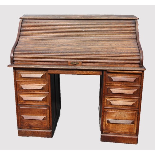 811 - An oak early 20th century oak roll top desk, the 'S' shaped tambour front enclosing a compartmentali... 