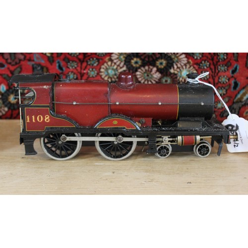 643 - An O Gauge clockwork 4-4-0 locomotive and tender, probably by Bassett-Lowke, in maroon L.M.S. livery... 