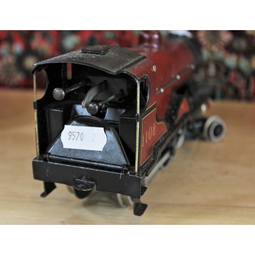 643 - An O Gauge clockwork 4-4-0 locomotive and tender, probably by Bassett-Lowke, in maroon L.M.S. livery... 