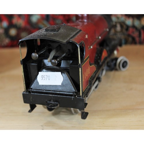 643 - An O Gauge clockwork 4-4-0 locomotive and tender, probably by Bassett-Lowke, in maroon L.M.S. livery... 