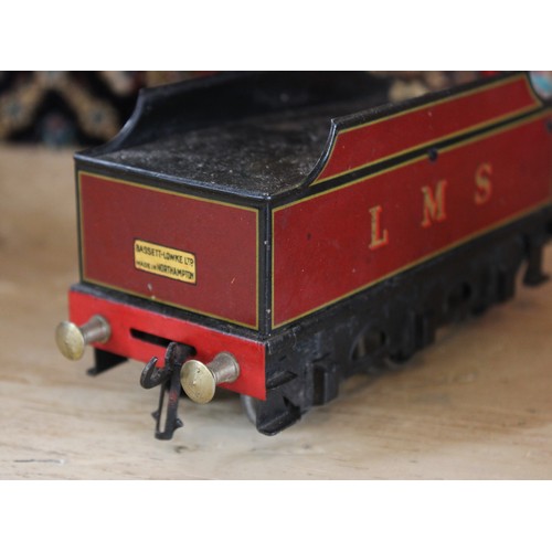 643 - An O Gauge clockwork 4-4-0 locomotive and tender, probably by Bassett-Lowke, in maroon L.M.S. livery... 