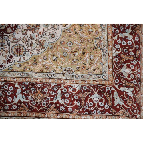 663 - A silkwork rug depicting birds amongst trees, within a repeating foliate border, 150cm x 107cm, alon... 