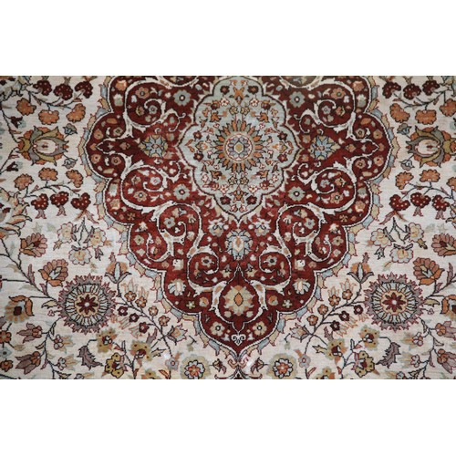 663 - A silkwork rug depicting birds amongst trees, within a repeating foliate border, 150cm x 107cm, alon... 