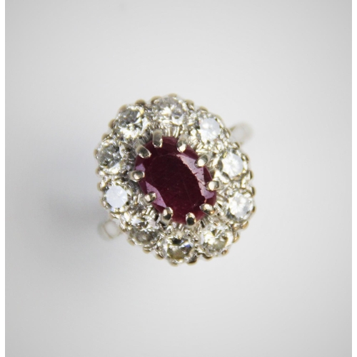 175 - A ruby and diamond cluster ring, comprising a central oval mixed cut ruby measuring 11mm x 8mm, claw... 