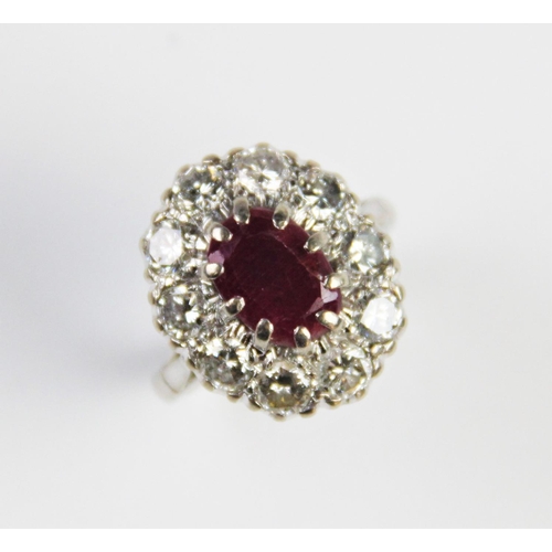 175 - A ruby and diamond cluster ring, comprising a central oval mixed cut ruby measuring 11mm x 8mm, claw... 