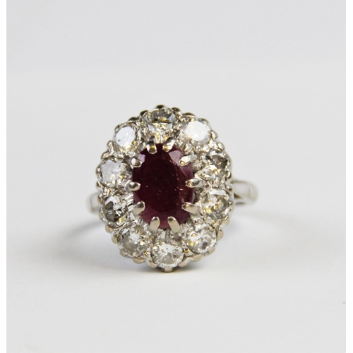 175 - A ruby and diamond cluster ring, comprising a central oval mixed cut ruby measuring 11mm x 8mm, claw... 