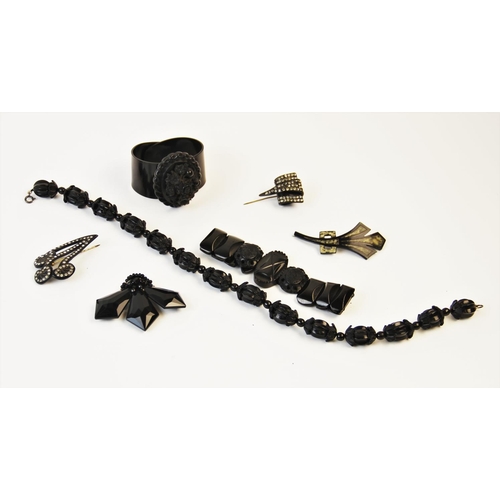 202 - A selection of jet coloured costume jewellery, to include a carved bead necklace, 38.5cm long, a car... 