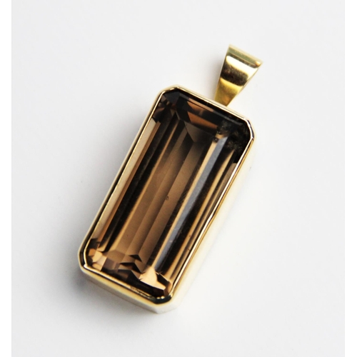 230 - A 9ct smoky quartz pendant, the central rectangular emerald cut quartz measuring 30mm x 15mm, set to... 