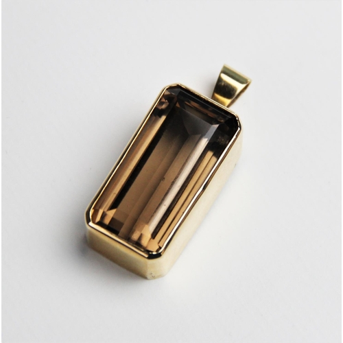 230 - A 9ct smoky quartz pendant, the central rectangular emerald cut quartz measuring 30mm x 15mm, set to... 