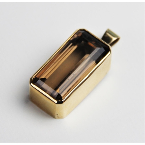 230 - A 9ct smoky quartz pendant, the central rectangular emerald cut quartz measuring 30mm x 15mm, set to... 