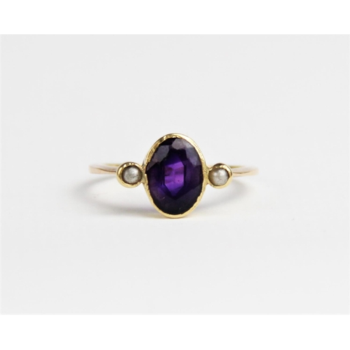 239 - An amethyst and pearl dress ring, comprising a central oval mixed cut amethyst measuring 9mm x 6mm, ... 