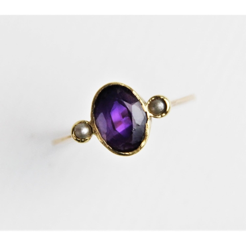 239 - An amethyst and pearl dress ring, comprising a central oval mixed cut amethyst measuring 9mm x 6mm, ... 