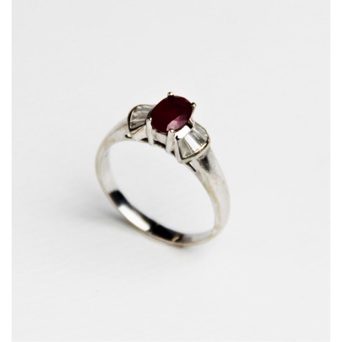 240 - A ruby and diamond 18ct gold ring, comprising a central oval mixed cut ruby measuring approx. 7mm x ... 