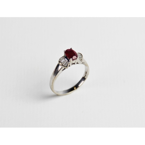 240 - A ruby and diamond 18ct gold ring, comprising a central oval mixed cut ruby measuring approx. 7mm x ... 