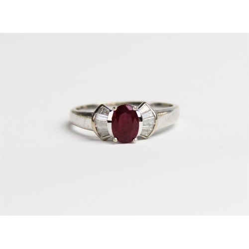 240 - A ruby and diamond 18ct gold ring, comprising a central oval mixed cut ruby measuring approx. 7mm x ... 