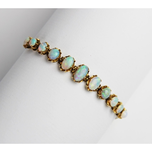 245 - An opal line bracelet, comprising eleven oval opal cabochons measuring between 5mm x 4mm and 10mm x ... 