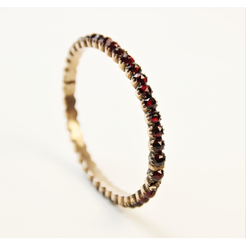 252 - A 19th century garnet set bangle, designed as a single row of forty rose cut garnets, all claw set t... 