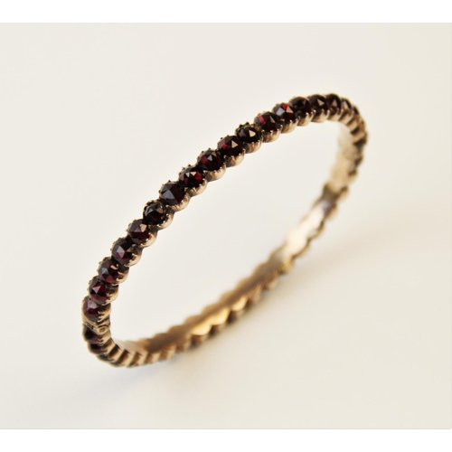 252 - A 19th century garnet set bangle, designed as a single row of forty rose cut garnets, all claw set t... 