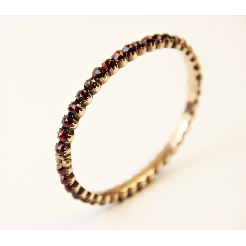 252 - A 19th century garnet set bangle, designed as a single row of forty rose cut garnets, all claw set t... 