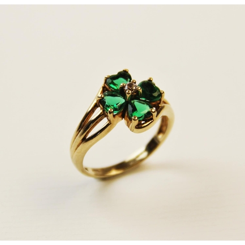 253 - A paste set 9ct gold four-leaf clover ring, the central cluster comprising four heart-shaped green p... 