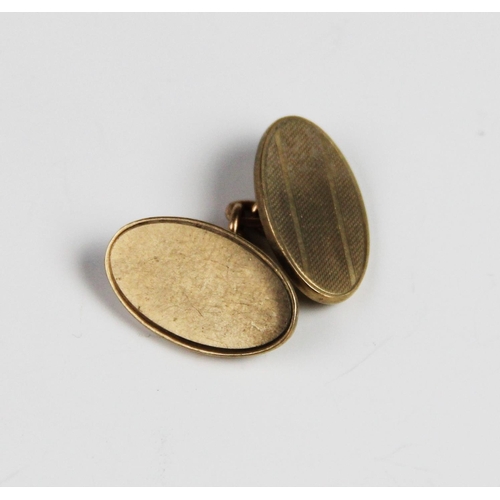 267 - A single 9ct gold cufflink, of oval form with engine turned decoration, 20mm x 13mm, weight 6.8gms