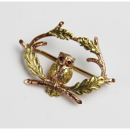 287 - A 9ct gold ruby set owl brooch by Cropp & Farr, designed as an owl sitting amongst oak branches with... 