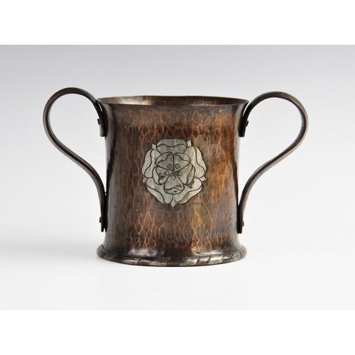 317 - A Hugh Wallis Arts & Crafts copper loving cup, early 20th century, the hand beaten cup of flared cyl... 