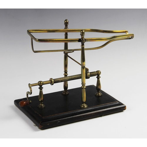 321 - A late 19th century wine decanting cradle, the frame formed from lacquered brass supported by turned... 