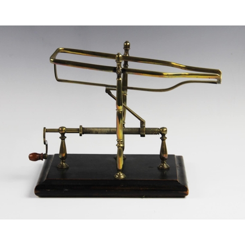 321 - A late 19th century wine decanting cradle, the frame formed from lacquered brass supported by turned... 