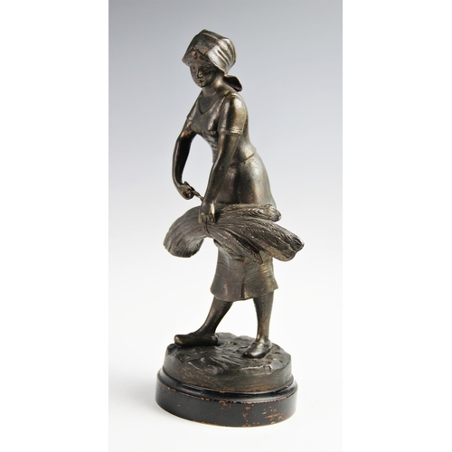 347 - Two cast spelter figures, 20th century, one modelled as a man sowing seed, the other as a woman bind... 