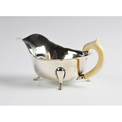 46 - A sauce boat with ivory handle by Emile Viner, Sheffield 1940, of typical form with shaped rim on th... 