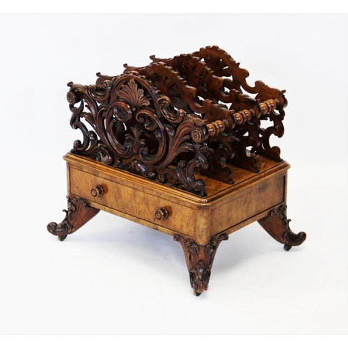 825 - A Victorian figured walnut Canterbury, the outer carved foliate open work dividers flanking a pair o... 