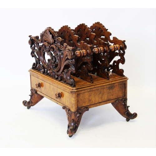 825 - A Victorian figured walnut Canterbury, the outer carved foliate open work dividers flanking a pair o... 