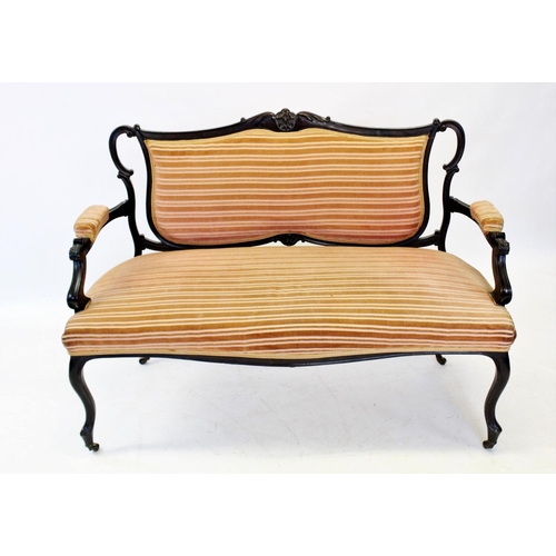 848 - An Edwardian mahogany two seater settee, the shaped padded back below a carved foliate crest extendi... 