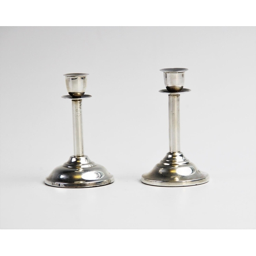 86 - A near pair of late Victorian novelty silver miniature candlestick, each of plain polished form on w... 