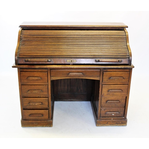 860 - An early 20th century oak roll top desk, the 'S' shaped tambour front enclosing a compartmentalised ... 